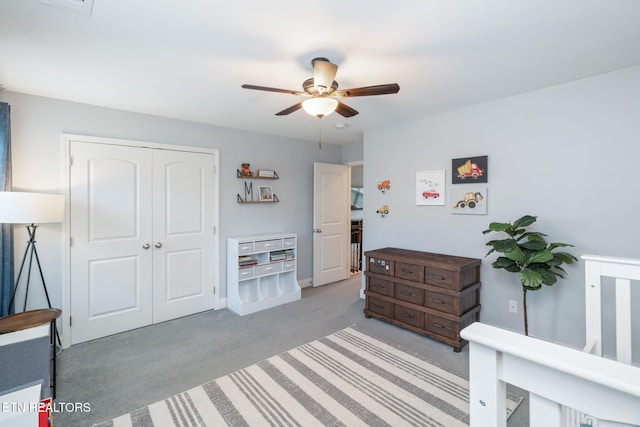 carpeted bedroom with ceiling fan and a closet