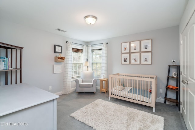 bedroom featuring a crib and carpet flooring