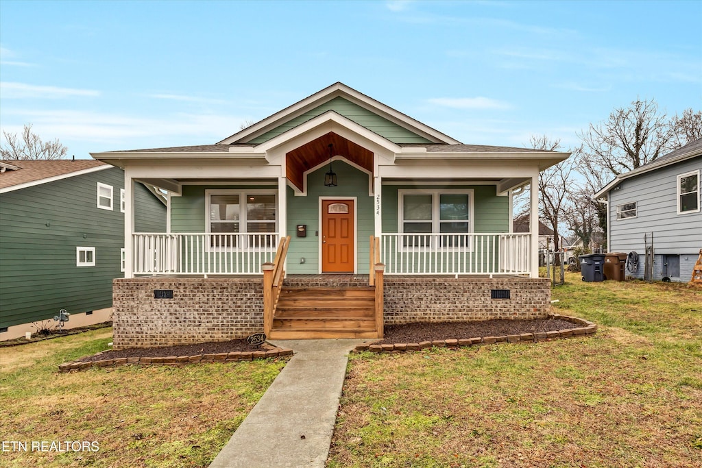 bungalow-style house with a porch and a front lawn