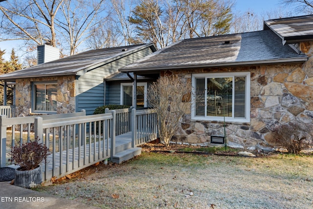 bungalow featuring a wooden deck and a front yard