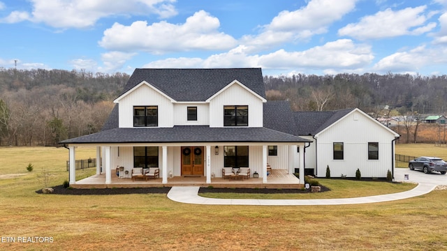 modern farmhouse style home featuring a porch and a front yard