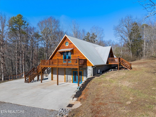 view of front facade with a garage, a wooden deck, and a front lawn