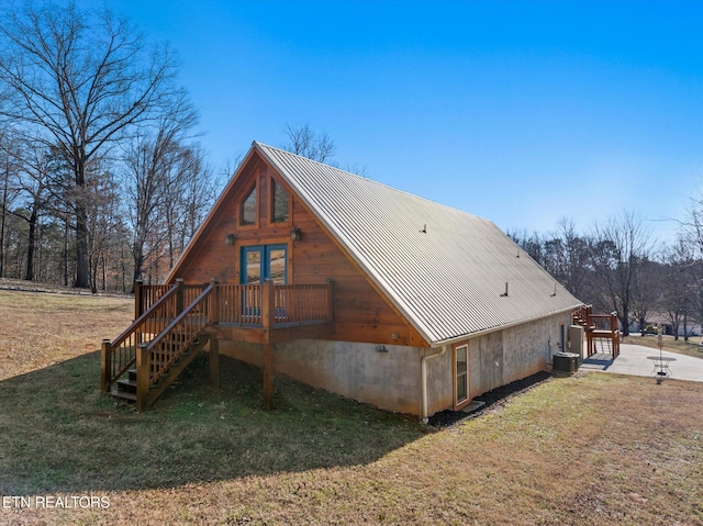 rear view of house with central AC and a yard