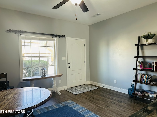 foyer entrance with dark wood-type flooring, visible vents, ceiling fan, and baseboards