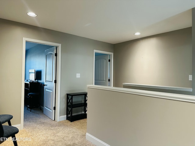 hall with light carpet, baseboards, and recessed lighting