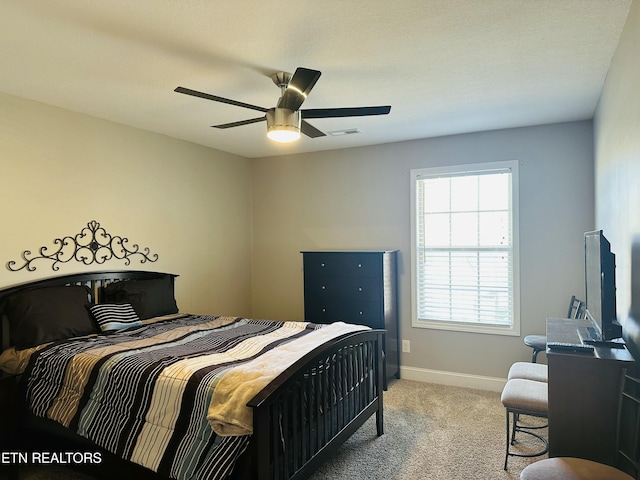 bedroom featuring baseboards, a ceiling fan, visible vents, and light colored carpet