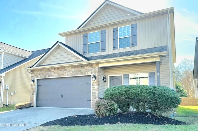 view of front of house featuring a garage, stone siding, board and batten siding, and concrete driveway