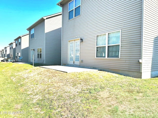 rear view of house with a patio area and a lawn