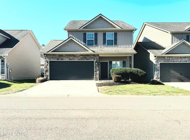 craftsman house with board and batten siding, a front yard, concrete driveway, and an attached garage