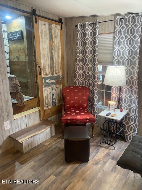 sitting room featuring a barn door and hardwood / wood-style floors