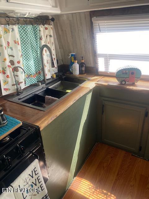 kitchen featuring sink, hardwood / wood-style floors, and range with gas stovetop