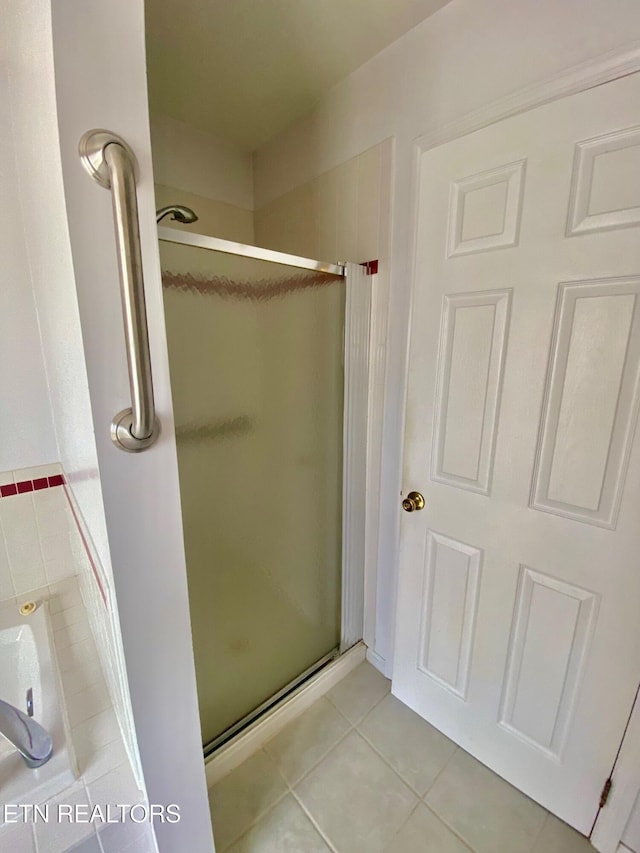 bathroom with tile patterned floors and a shower with shower door