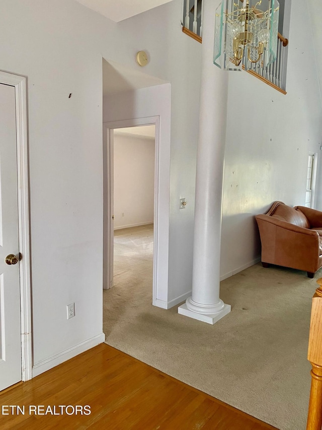 hall with carpet floors and decorative columns