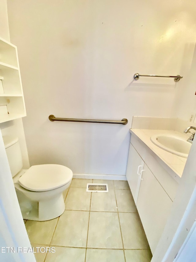 bathroom featuring vanity, tile patterned floors, and toilet