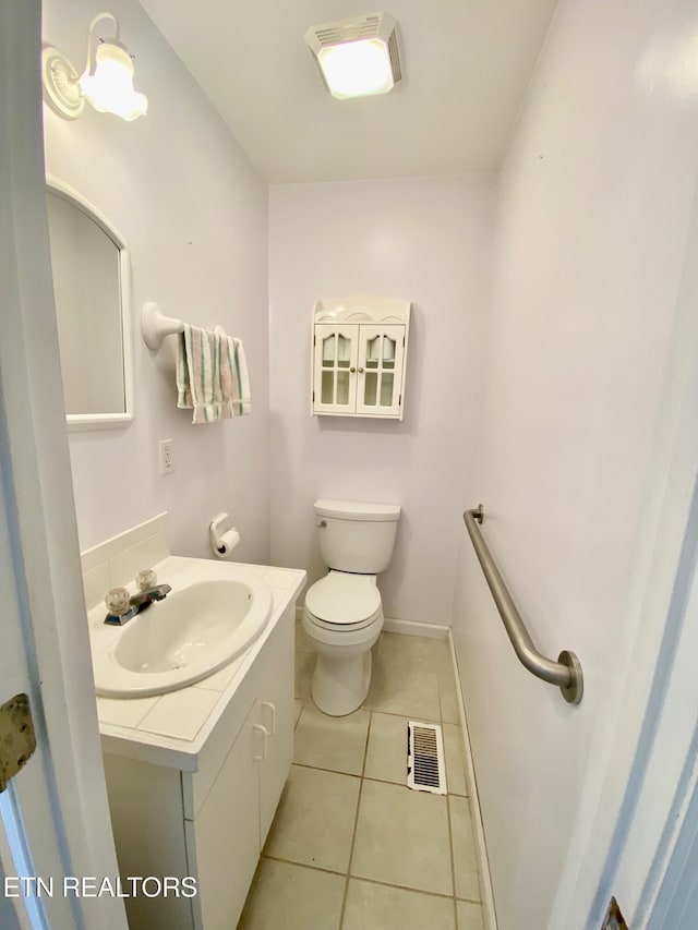 bathroom featuring vanity, tile patterned floors, and toilet