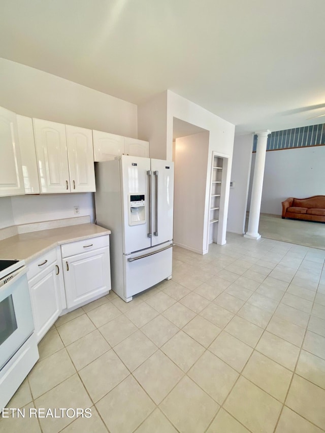 kitchen with light tile patterned floors, white appliances, decorative columns, and white cabinets