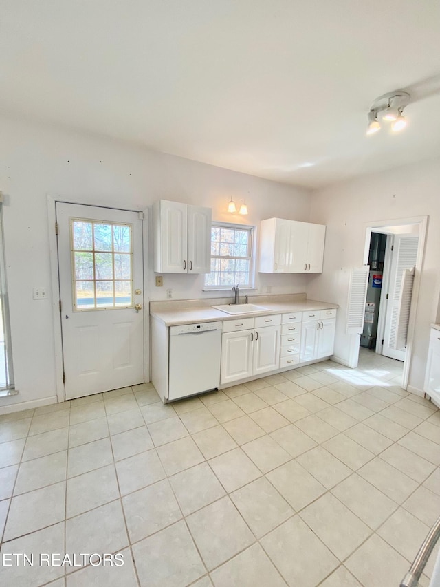 kitchen with white dishwasher, sink, white cabinetry, and light tile patterned floors