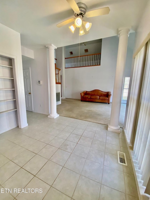 interior space with light tile patterned floors, built in shelves, decorative columns, and ceiling fan