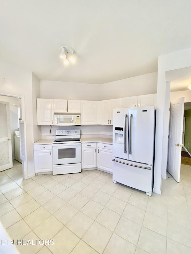 kitchen featuring white cabinetry, white appliances, washer / clothes dryer, and light tile patterned floors