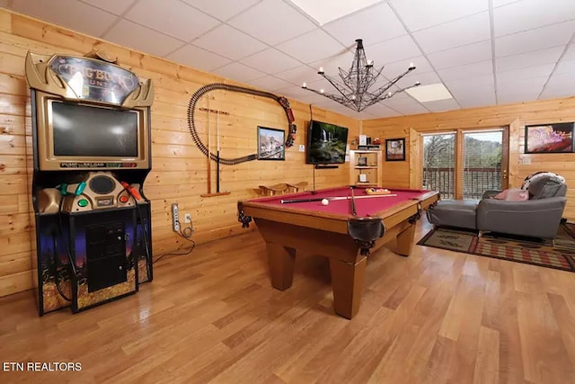 rec room featuring hardwood / wood-style flooring, pool table, wooden walls, and a paneled ceiling