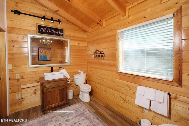 bathroom with toilet, wood walls, wood ceiling, vaulted ceiling with beams, and hardwood / wood-style floors