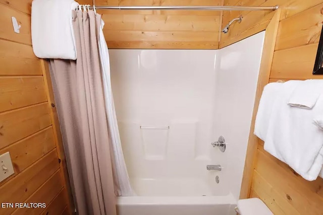 bathroom with shower / tub combo with curtain and wooden walls