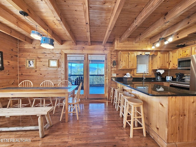 kitchen featuring pendant lighting, sink, stainless steel appliances, dark hardwood / wood-style floors, and beamed ceiling