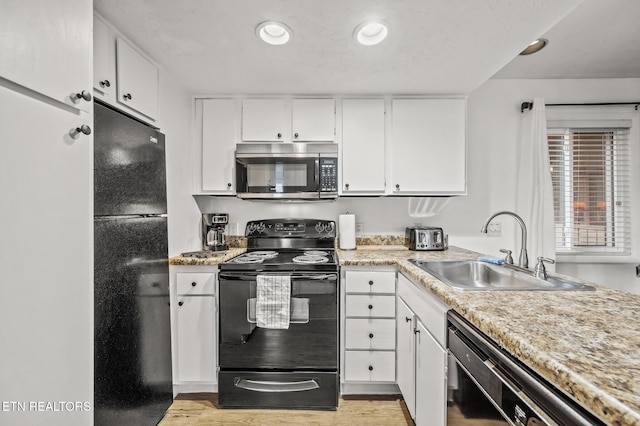 kitchen featuring white cabinets, sink, light hardwood / wood-style flooring, and black appliances