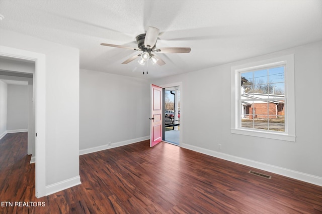 spare room featuring ceiling fan, dark hardwood / wood-style floors, and a textured ceiling