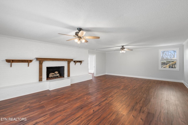 unfurnished living room featuring crown molding, a textured ceiling, dark hardwood / wood-style floors, ceiling fan, and a fireplace