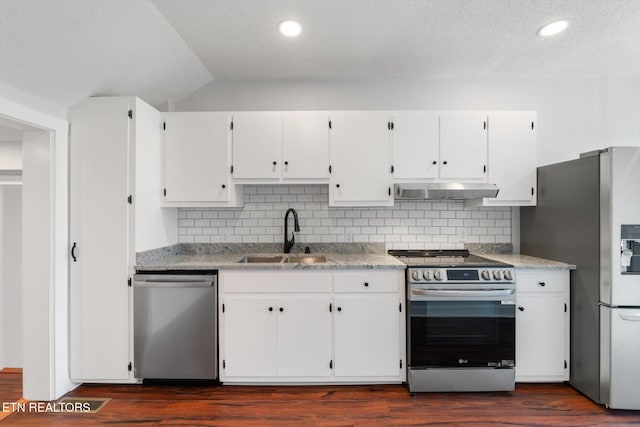 kitchen with appliances with stainless steel finishes, white cabinetry, sink, backsplash, and dark hardwood / wood-style flooring