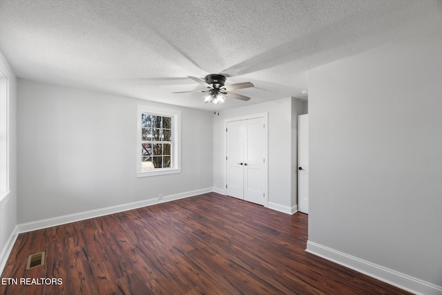 unfurnished bedroom featuring ceiling fan, dark hardwood / wood-style floors, a closet, and a textured ceiling