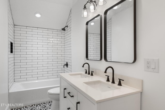 full bathroom with tiled shower / bath, vanity, and toilet