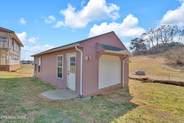 view of outdoor structure featuring a garage and a lawn