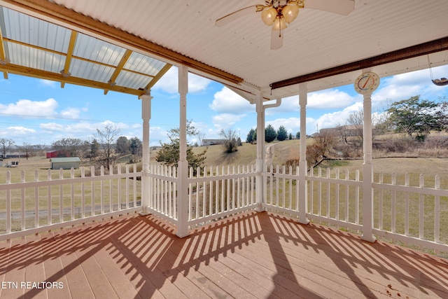 deck featuring ceiling fan and a rural view