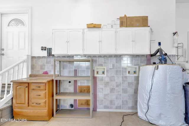 interior space featuring light tile patterned floors and cabinets