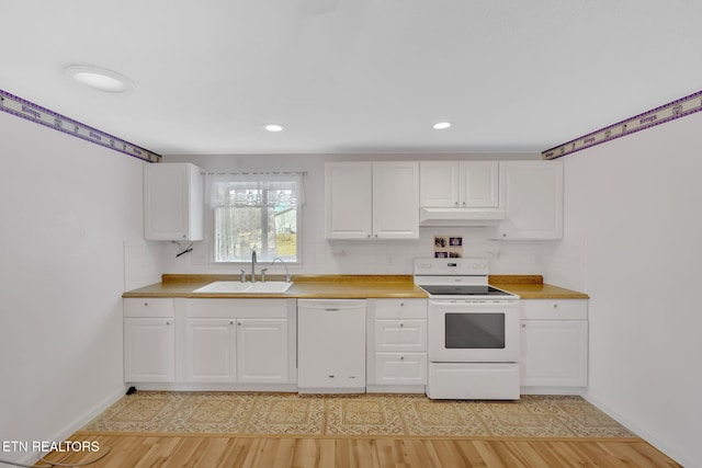 kitchen featuring white appliances, sink, decorative backsplash, and light wood-type flooring