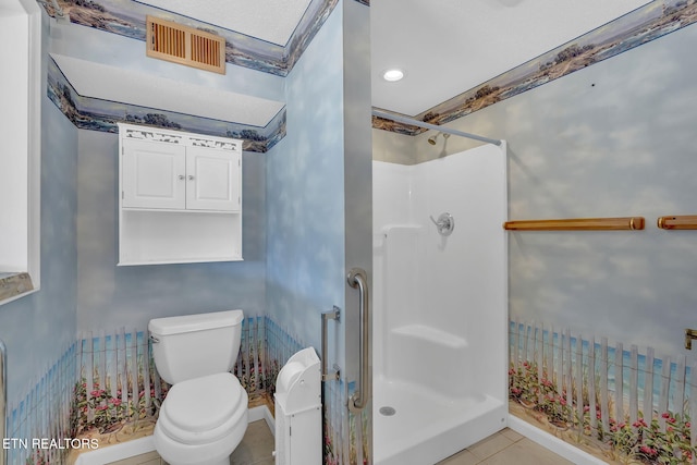 bathroom with a shower, tile patterned floors, and toilet