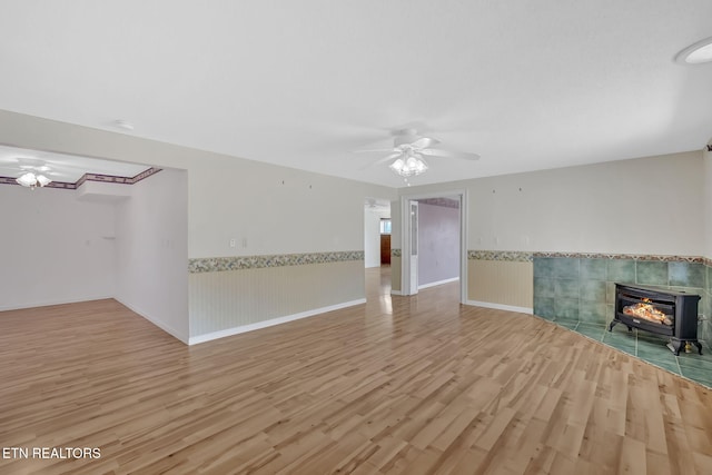 unfurnished living room featuring ceiling fan and light hardwood / wood-style flooring