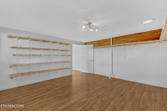 unfurnished room with wood-type flooring and a textured ceiling