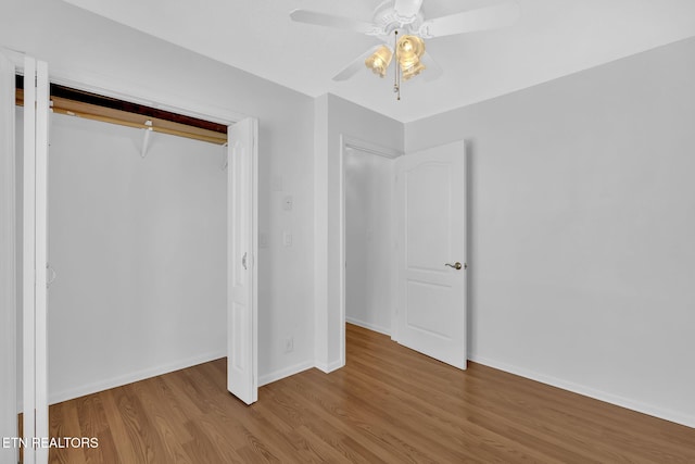 unfurnished bedroom featuring ceiling fan, hardwood / wood-style floors, and a closet