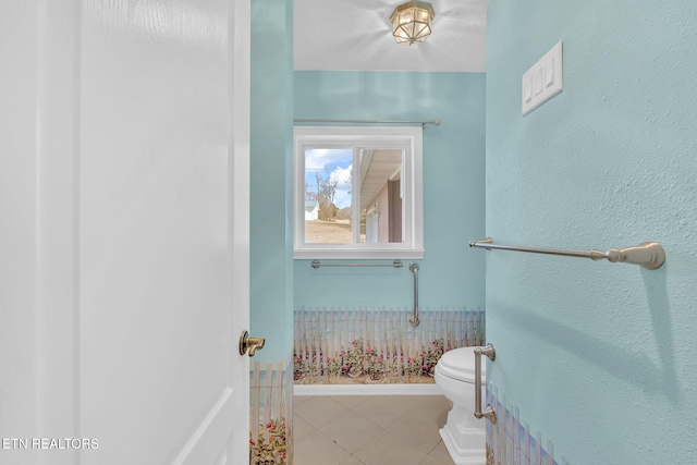 bathroom featuring toilet and tile patterned flooring