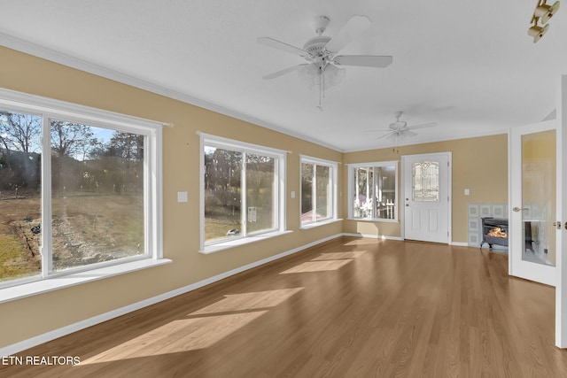 unfurnished sunroom with a fireplace and ceiling fan