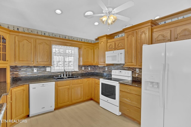 kitchen with tasteful backsplash, sink, dark stone countertops, and white appliances