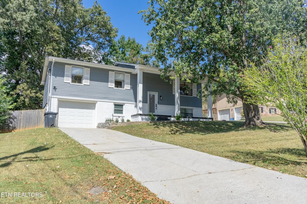 split foyer home with a garage and a front yard