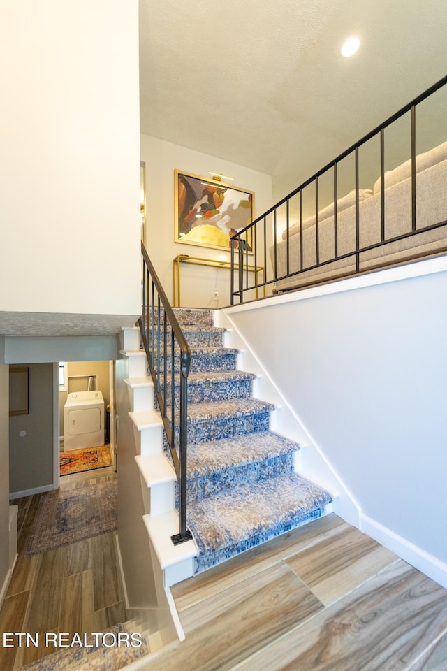 stairs featuring washer / clothes dryer and hardwood / wood-style flooring