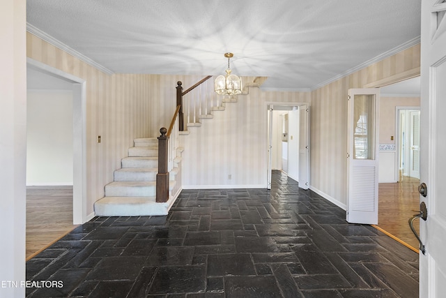 entryway with an inviting chandelier, crown molding, and a textured ceiling