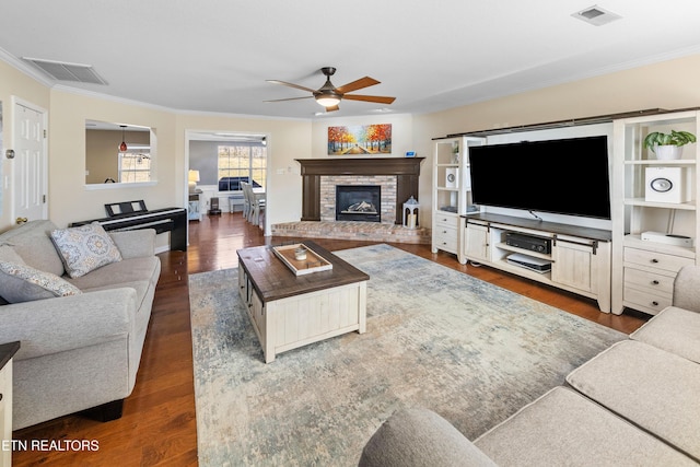 living room with crown molding, dark wood-type flooring, and ceiling fan