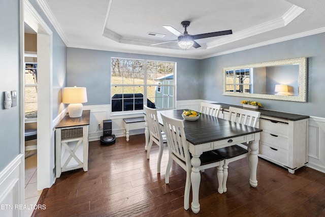 dining room featuring dark hardwood / wood-style floors, ornamental molding, and a tray ceiling