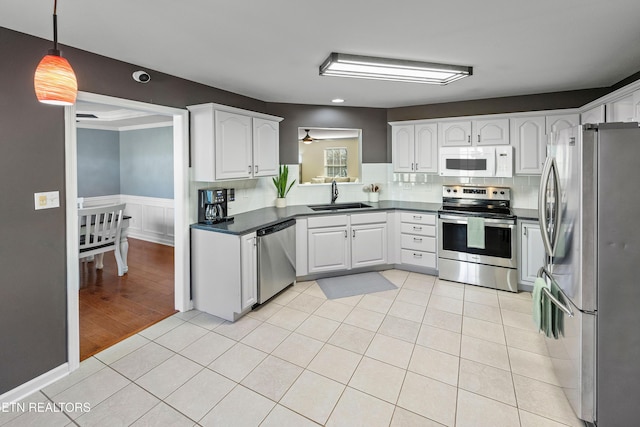 kitchen with sink, white cabinetry, hanging light fixtures, light tile patterned floors, and appliances with stainless steel finishes